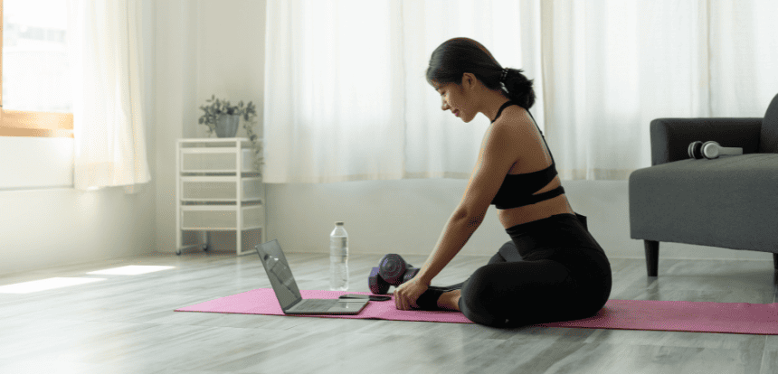 femme en tenue de yoga assis devant son pc